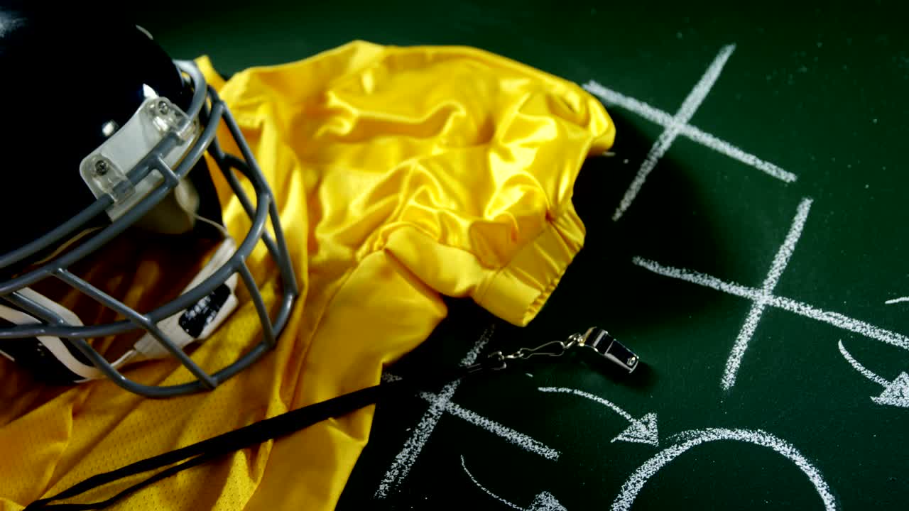 camiseta, silbato del árbitro y equipo de cabeza en el tablero verde 4k