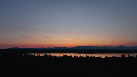 aerial view of the sun setting over the puget sound with the cascade mountains off in the distance