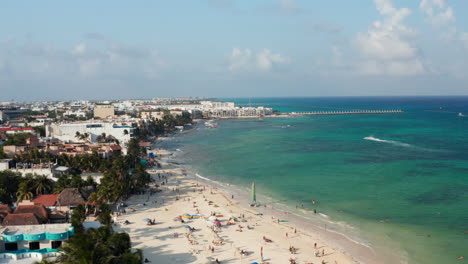 Tourists-sunbathing-on-the-sandy-beach.-Aerial-orbit-shot-with-the-riviera-at-Playa-del-Carmen,-Mexico