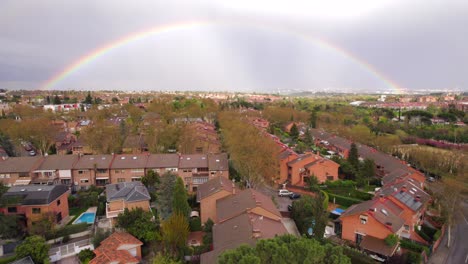 Full-rainbow-over-residential-houses-in-Spanish-neighborhood-after-rain