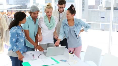 equipo de moda haciendo una lluvia de ideas juntos usando una computadora portátil