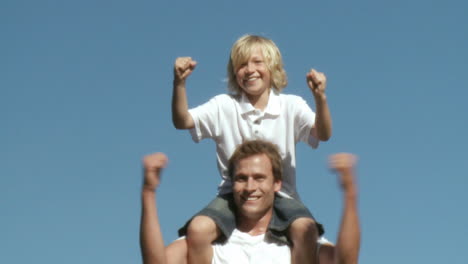 Athletic-Father-with-his-son-on-his-shoulders-showing-team-spirit