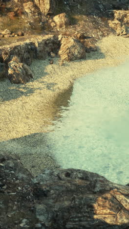 tranquil beach scene with rocks and clear blue water