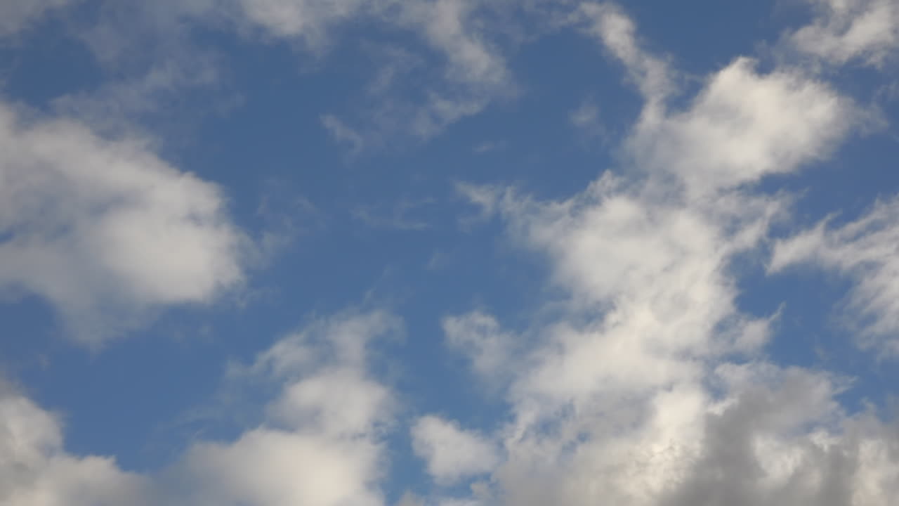 A POV SHOT of a rotating blue sky with fluffy clouds.