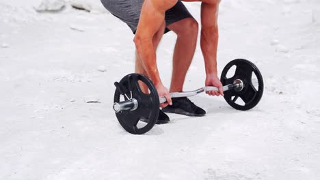 men's hands lift the barbell from the ground. workout in nature