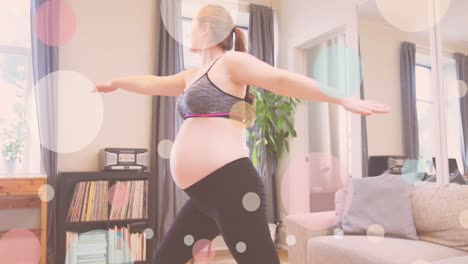 animation of colourful spots over caucasian pregnant woman exercising at home