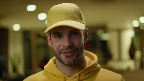 Young-courier-smiling-at-camera.-Delivery-man-in-uniform-looking-at-camera