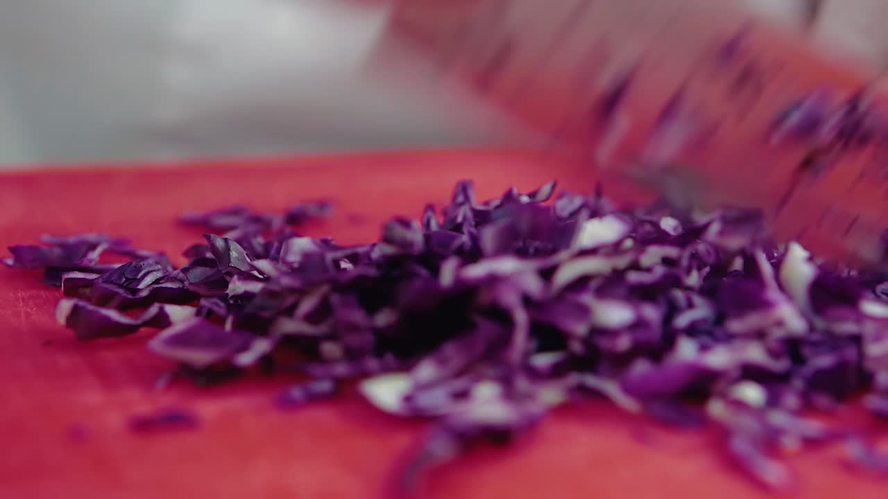 el cocinero corta una cebolla azul con un cuchillo