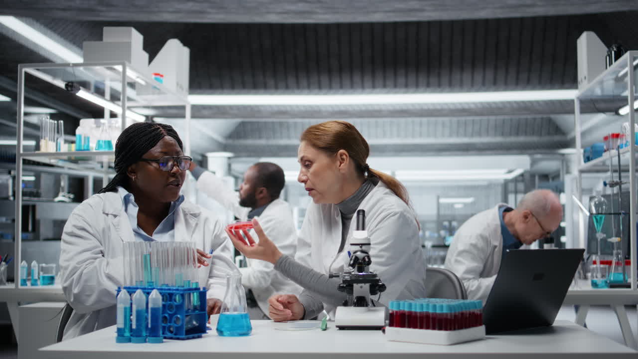 Team of female researchers doing brainstorming, looking at petri dish sample