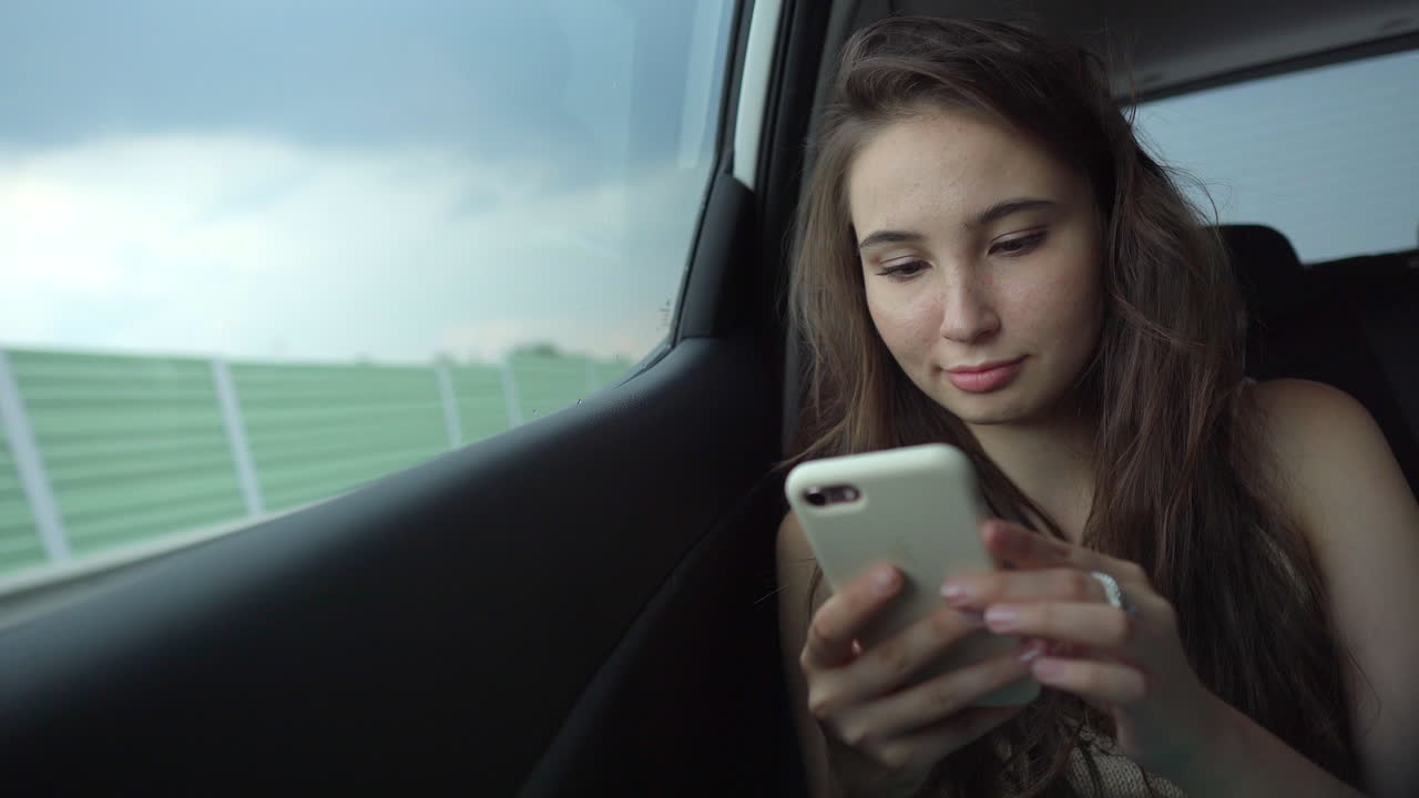 joven usando un teléfono inteligente en un coche