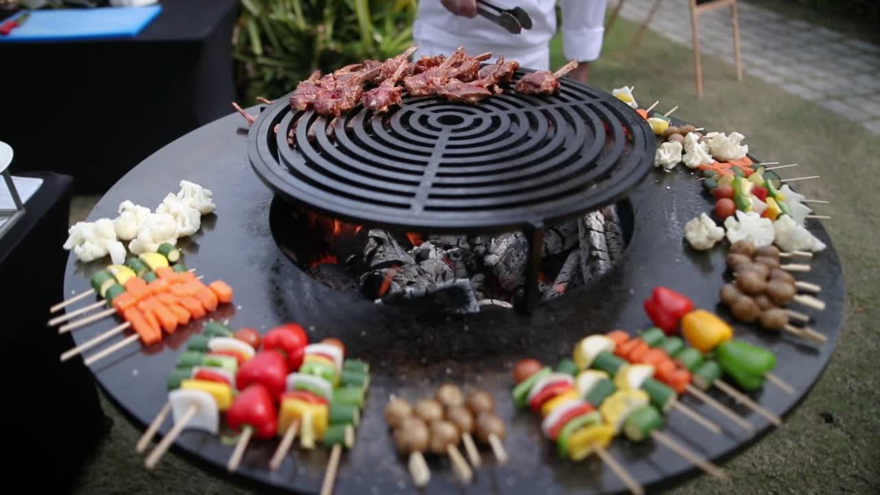 Chef che prepara spiedini di carne e verdure sulla griglia