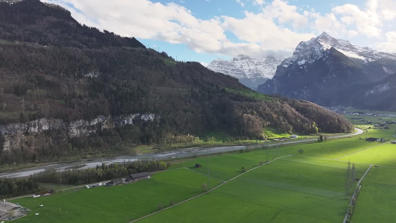 fotografía aérea de un valle verde y exuberante cerca de weesen, suiza, con un telón de fondo montañoso y una autopista