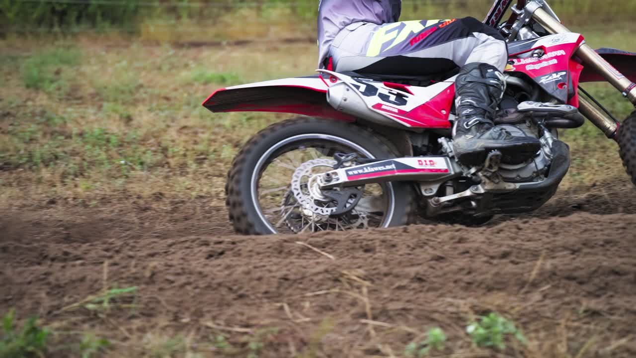 Motociclista de corrida espalha areia ou terra com a roda traseira