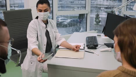 doctor writing prescription for patient