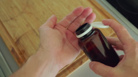manos abiertas tapa de la botella de embalaje y verter algunas píldoras en la palma