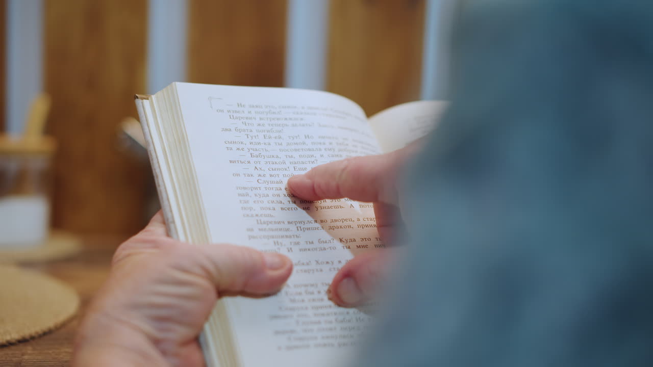 Caucasian grandma reading braille recipe closeup hands tracing raised dots on worn pages beside teacup on wooden table warm sunlight cozy kitchen scene slow deliberate motion conveying memory