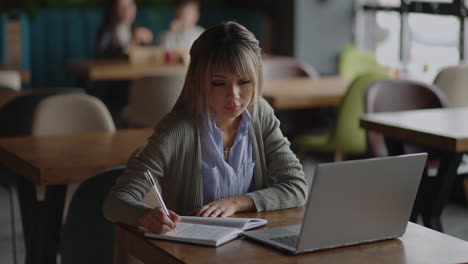 Joven-Y-Bella-Mujer-De-Negocios-Asiática-Sonriente-Sosteniendo-Un-Café-Y-Una-Computadora-Portátil-Colocada-En-La-Mesa-De-Madera-De-La-Oficina.-Mujer-Revisando-El-Correo-O-Investigando-Mientras-Teletrabaja