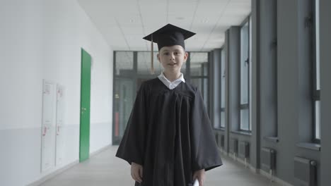 small boy trowing his mortarboard up in the air.