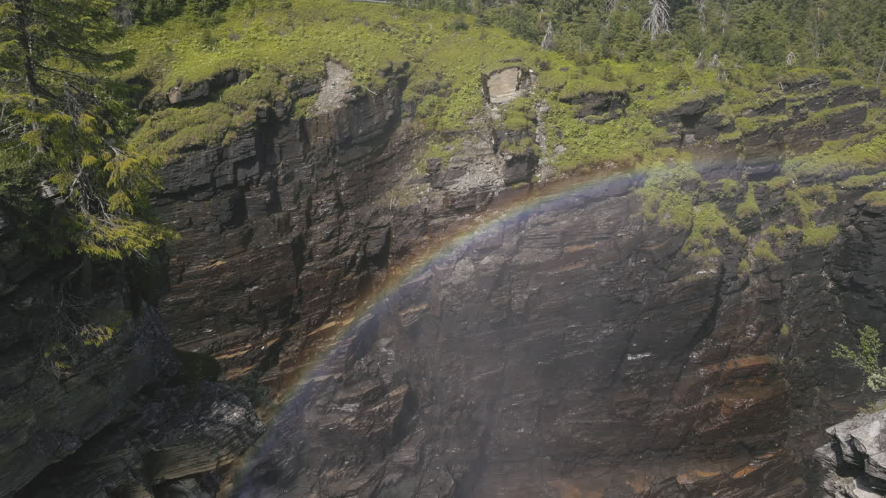 impresionante arco iris formado en la niebla dentro de un enorme y profundo cañón rocoso parcialmente cubierto por vegetación