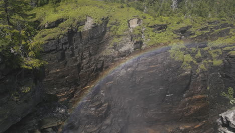 Atemberaubender-Regenbogen,-Der-Sich-Im-Nebel-In-Einer-Riesigen-Und-Tiefen-Felsschlucht-Bildete,-Die-Teilweise-Von-Vegetation-Bedeckt-War