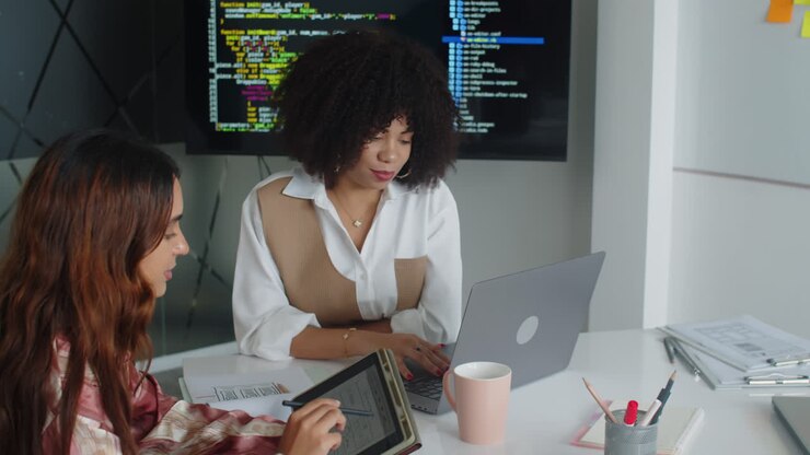 Female Developers Working Together on Task at Office