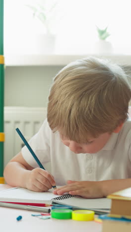 little boy finds solution of difficult maths problem at desk in home classroom. toddler student does tasks preparing for future school lessons in nursery