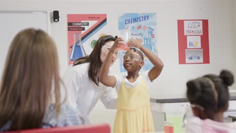 diversas maestras y niñas haciendo experimentos en la clase de química de la escuela primaria, cámara lenta
