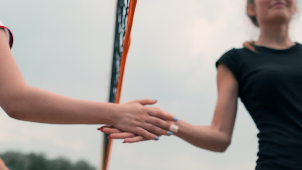 primer plano saludando las manos de las jugadoras de voleibol agradeciendo al oponente por el último partido en cámara lenta