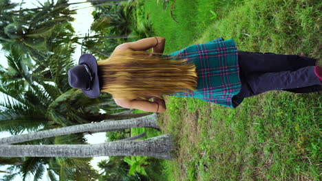 Beautiful-redhead-enjoying-tropical-jungle,-vertical-shot-for-social-media