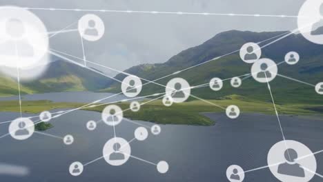 animation of connected icons over aerial view of lake and mountain against cloudy sky