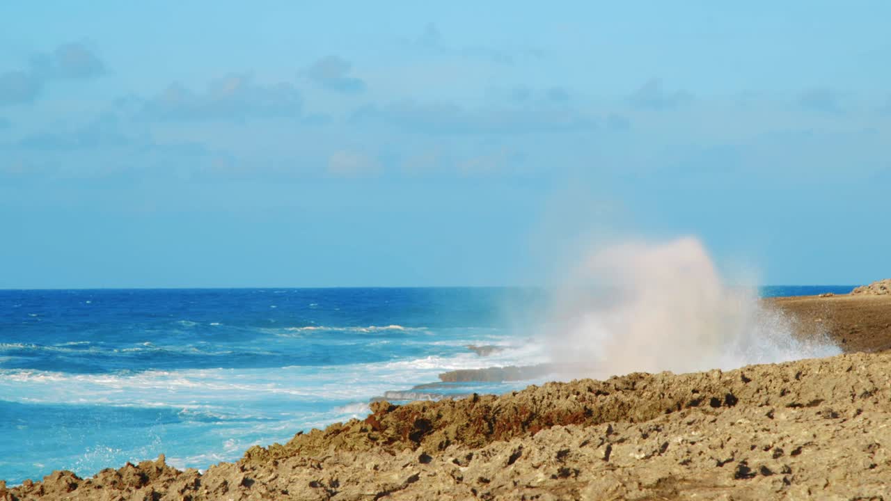 산호 해안에 부서지는 파도와 안개 낀 물보라를 공중으로 높이 보내는