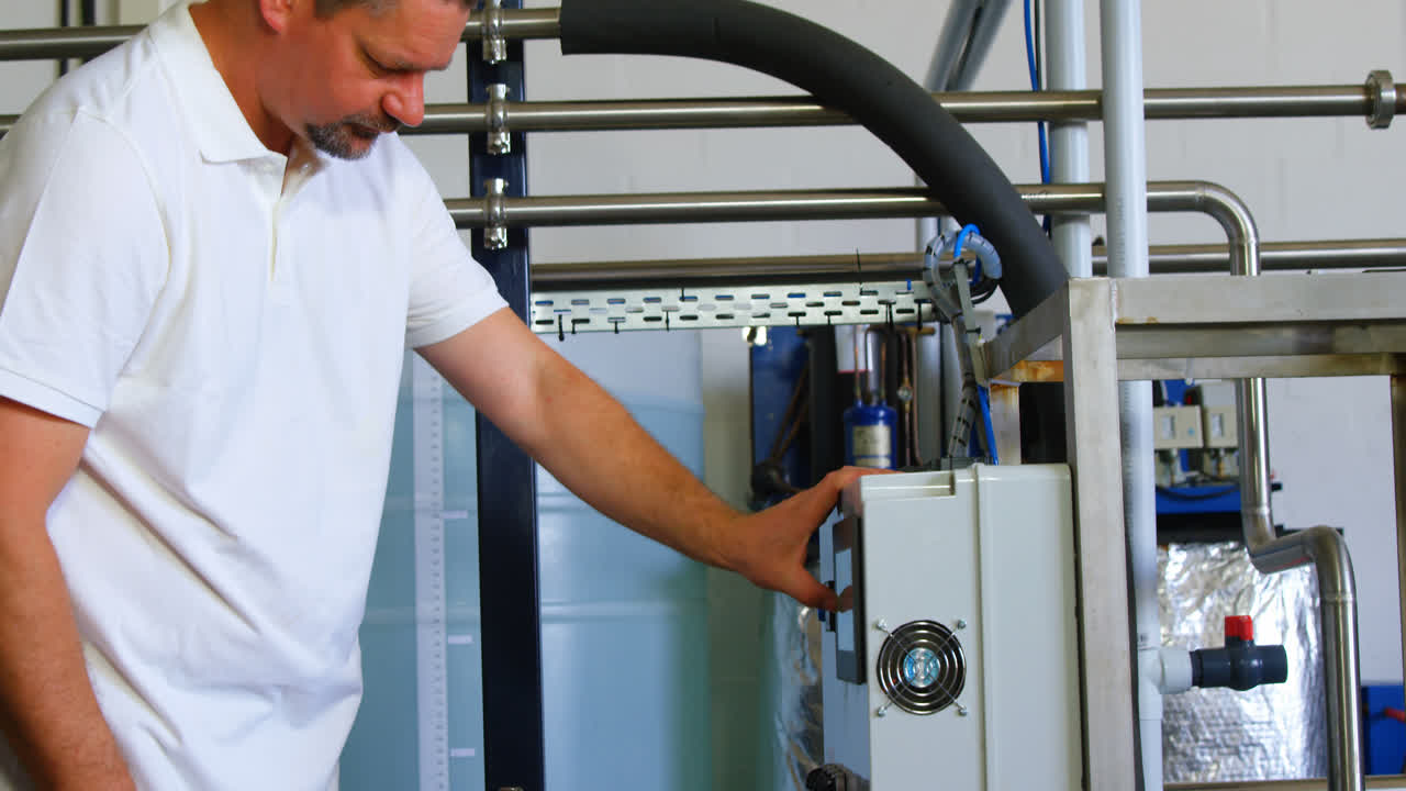 trabajador masculino que opera una máquina en una fábrica 4k