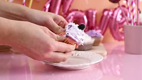 breaking  delicious strawberry cup cake with light purple lavender color cream in two parts. close up