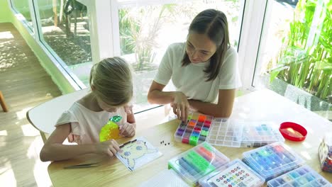 mother and daughter doing a beading project