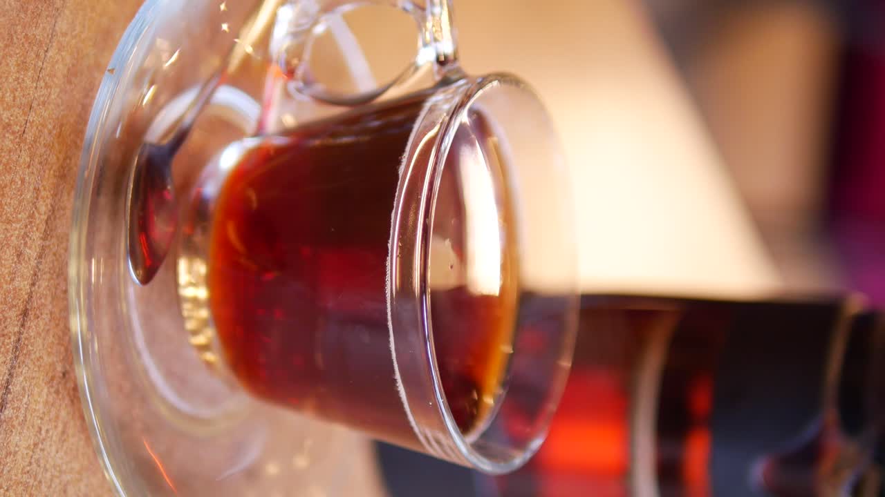 Glass tea cup with tea on a wooden table
