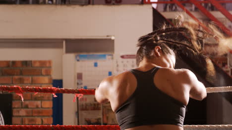 una boxeadora cansada de pie en el ring