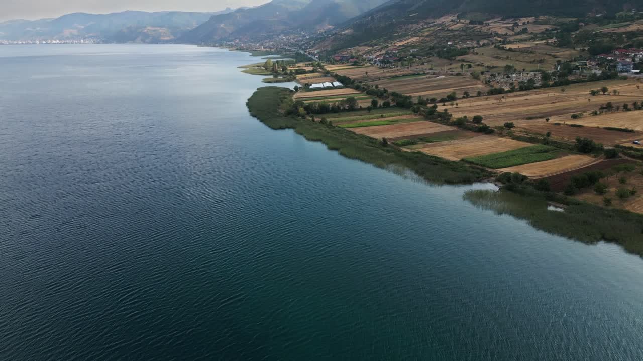 Большое Охридское озеро возле гор летом, красивый солнечный свет и зеленый луг, Охридское озеро, Албания, Европа, дрон