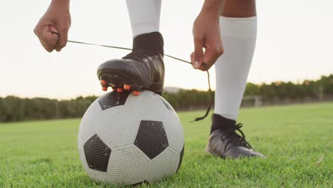 video de un jugador de fútbol biracial con la pelota atada a los cordones