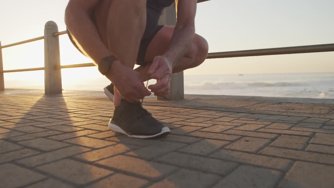 sección baja de un hombre mayor atando sus cordones de zapatos