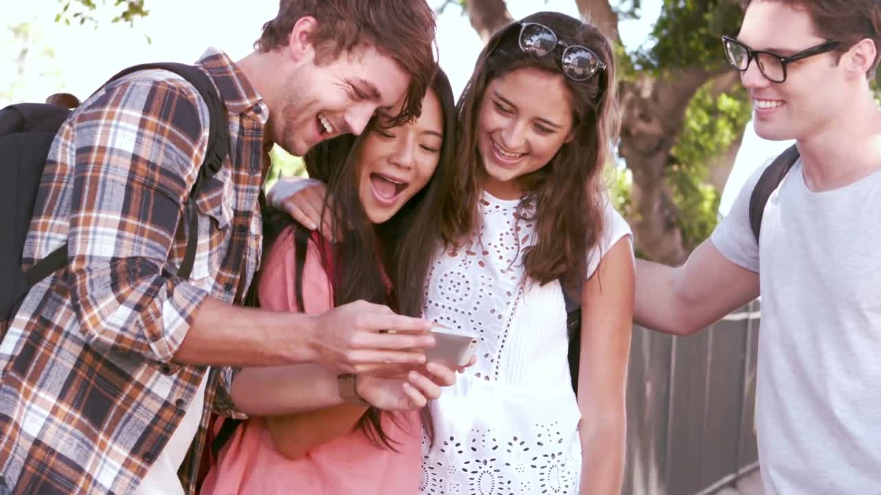 amigos hipsters riendo mientras miran el teléfono inteligente