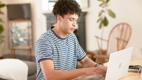 Hombre-Birracial-Trabajando-Desde-Casa-Usando-Una-Computadora-Portátil,-Cámara-Lenta