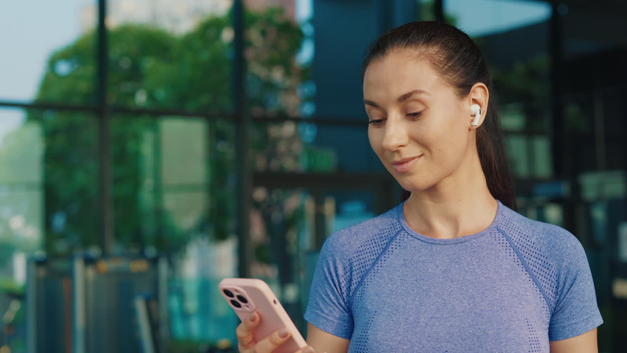 Woman using phone in a gym
