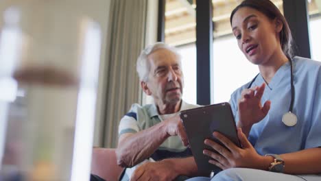 Animation-of-biracial-female-doctor-with-tablet-talking-with-caucasian-senior-man