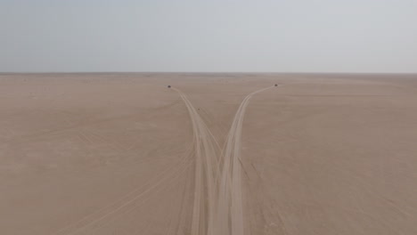 two 4x4 vehicles split on desert tracks toward bar al hikman, oman, aerial view