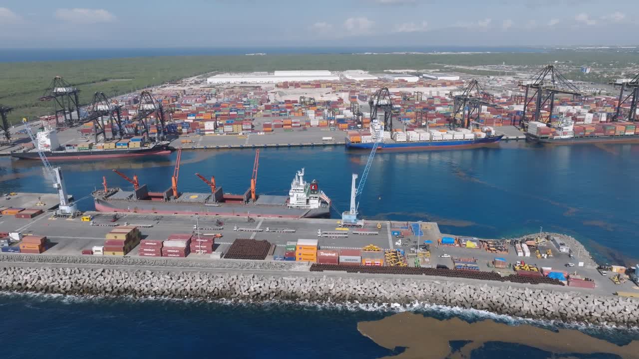 vista aérea del puerto multimodal de caucedo con grúas industriales y contenedores para operaciones de carga - boca chica, república dominicana