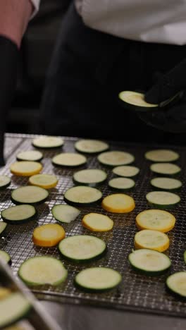 chef preparando calabacín en rodajas y calabaza amarilla para deshidratar