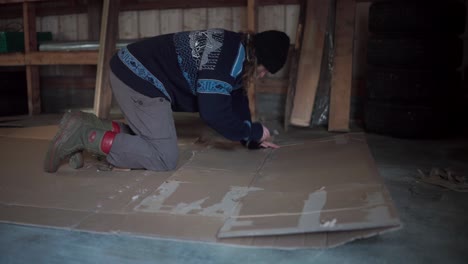 a man is getting cardboard ready for use as mulch in gardening - close up