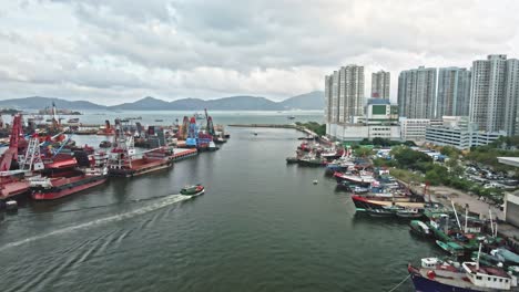 Top-view-of-vessel-cruising-out-to-sea-from-Typhoon-Shelter,-Hong-Kong