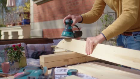 sanding the wood with help of a grinding machine