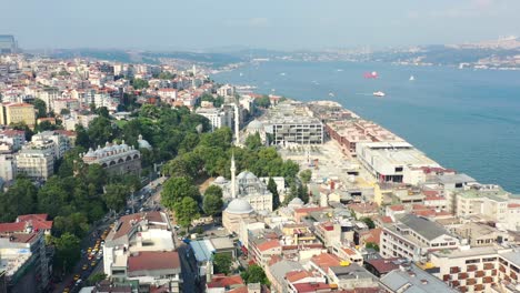 aerial view of european buildings in karakoy, istanbul turkey on a sunny summer day as boats cross the bosphorus river